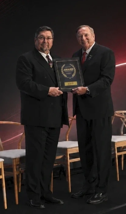 David A. Ward Sr. holding an award on stage